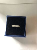 Silver-tone Swarovski crystal cluster ring displayed in a blue velvet ring box showing front and top view