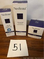 Full lot of three boxed NeoStrata skincare products on display including Youth Factor GF serum and FirmaLift firming products with the number 51 card in front.