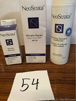 Photo showing three NeoStrata skincare products in their boxes: Blemish Spot Gel, Wrinkle Repair Moisturizing Cream SPF 30, and Purifying Solution.