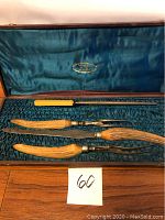 Four-piece antique cutlery set with horn and ivory handles in original box with blue fabric lining.