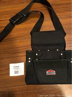 Front side of black Jobmate toolbelt showing compartments and logo