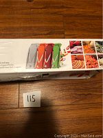 Photo of the packaging box for the colorful Swissmar mandoline slicer showing multiple color options and vegetable cuts that can be made