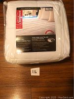 Packed Sunbeam premium heated mattress pad in white, twin size, showing front package label with brand, size, and some features.
