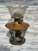 Front view of antique brass oil lamp with frosted glass etched shade.