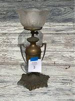 Antique brass gas lamp with frosted etched glass shade and ornate base, front view