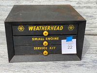 Front view of antique Weatherhead black metal cabinet with three drawers labeled Weatherhead, Small Engine, and Service Kit in yellow lettering.