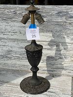 Full view of the antique metal lamp base showing the three light sockets and decorative column.