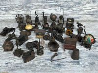 Full lot showing all 30 miniatures in a vintage bronze finish resembling antique objects including a globe, locomotive, lanterns, sewing machine, and more.