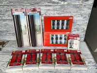Photo showing six packages of Hamilton Victorian Street Lamp sets, two red boxed sets of black decorative fence pieces, and two rolls of PVC pebble mats in original packaging.