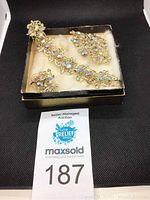 Photo of Coro iridescent rhinestone set showing necklace, brooch, and clip-on earrings in box with auction label
