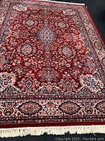 Full view of red area rug laid out on floor showing overall pattern and condition