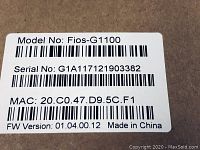 Close-up photo of label showing Model No: Fios-G1100 with serial number and MAC address.