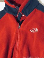 Close-up of front zippered fleece jacket showing The North Face logo and collar