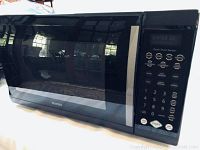 Front view of the black Sears Kenmore microwave with glass door and digital control panel.