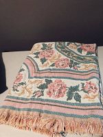 Folded fleece throw blanket showing floral patterns with roses, leaves, and stripes.