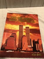 Hardcover book titled 'The History of the World Trade Center' with a photographic cover showing the Twin Towers at sunset.