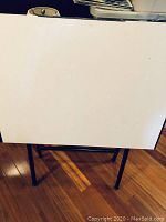 Front view of the white rectangular tabletop showing its surface and black frame beneath