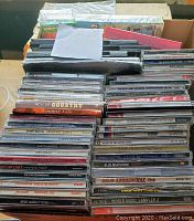 Two boxes stacked with multiple music CDs visible on top