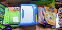 LeapFrog LeapPad console alongside several spiral-bound books for math and reading