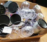 Magic Bullet blender base, clear plastic blender cups and lids in a cardboard box