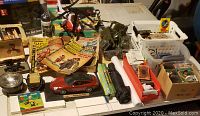 Full view of lot including Porsche model, collectible comics, army trucks, trading cards, and incense.
