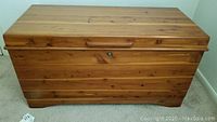 Full view of Lane cedar chest closed, showing natural wood finish and lock on front.