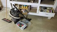 Photo of Sears wet/dry vacuum and assorted painting supplies underneath a workshop counter.
