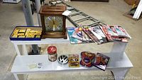 Photo showing the Howard Miller mantel clock, collectible magazines, collectible labels, and canisters arranged on shelving