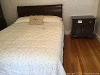 Full room view showing queen headboard attached to frame and matching nightstand beside it.