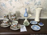 Overview of all items including Lefton cups and saucers, Lenox pieces, Wedgwood jasperware plates and lid, and white Lenox vase.