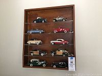 Full view of wooden display shelf with ten diecast cars arranged on five clear acrylic shelves