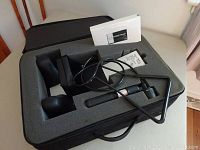 Full kit components laid in foam insert inside the carrying case showing the traction frame, adjustable neck wedges, pump, and instruction manual.