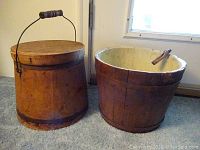 Both antique wooden buckets side by side showing the firkin with lid and the open bucket.