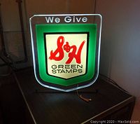 Front lit view of sign on table showing illumination and stand