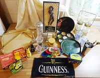 Overview of lot showing various barware items, cocktail mixers, Guinness towel, Canadian Club plaque, metal trays, and other vintage memorabilia.