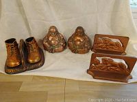Photo showing the bronze baby shoe sculptures, two bronze Buddha statues, and two Lion of Lucerne bronze bookends.