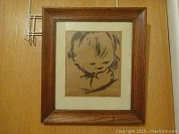 Framed original lithograph titled "Bunky" showing abstract, minimalist portrait of a boy's head and shoulders on tan paper, in oak wood frame.