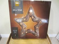 Photo of boxed 24 inch LED star decoration in original packaging labeled as Holiday Time brand, warm white lights, remote control included.