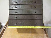 Front view showing the 5 drawers with stenciled text 'Genuine Parts' and 'Carburetor' with a measuring tape across the base showing approximate width.