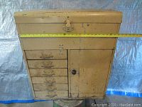 Front view of vintage metal tool box showing six drawers on the left and a side door on the right, closed.