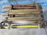 Top view of vintage wooden laundry wringer with visible rubber rolls and crank mechanism. Tape measure indicating width approximately 15 inches.