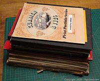 Stack of art books and portfolios showing Currier & Ives Print Portfolio on top.