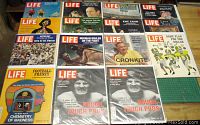 Top view of 15 LIFE magazines arranged in a grid showing colorful front covers with sports, cultural and historical themes.