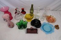 Overview of colored and art glass items arranged on white background showing wide variety of shapes and colors.