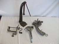 Various vintage kitchen tools including apple corer, bottle capper, meat grinder, and press on white sheet background.