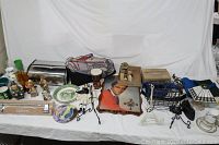Overview of lot showing a variety of kitchen items, collectibles, decorative items including a vintage bread box, vases, plates, and figurines arranged on a table with white backdrop.