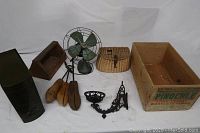 Full lot assortment including vintage fan, shoe forms, wicker basket, wooden advertising box, black metal box, lantern holder, and metal holder.