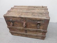 Full front view of the wooden trunk showing the top and locking hardware.