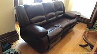Front angled view of the chocolate-brown leatherette recliner sofa showing seating area and arms