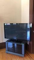 Front view of TV on stand in room corner